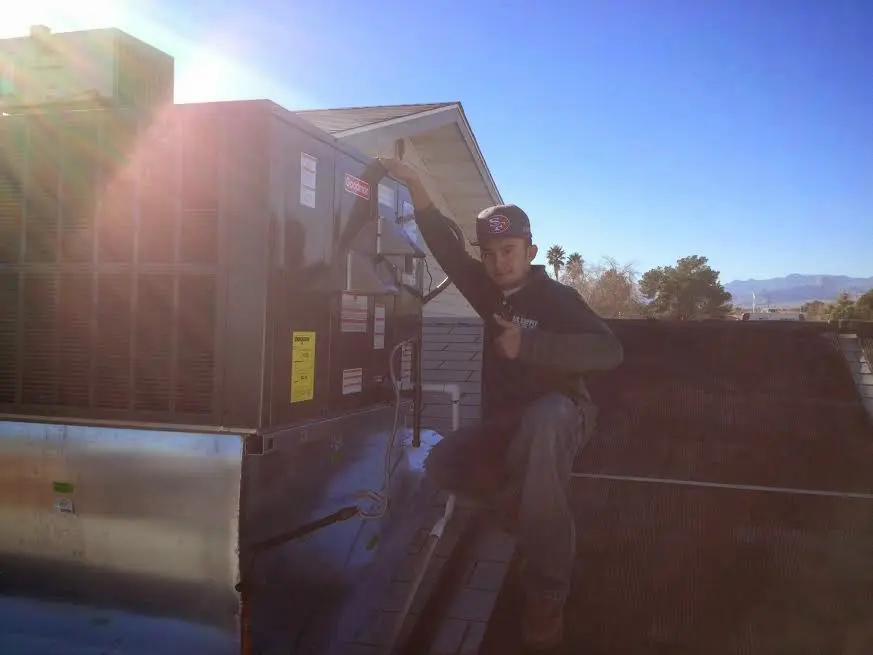HVAC technician performing HVAC Inspection on a rooftop unit in Gilmer